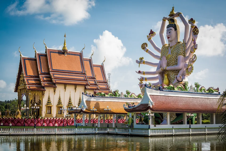 Wat Plai Laem temple and its statue beside the lake
